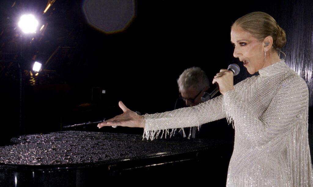 A grab of a video released by the Olympic Broadcasting Services shows Canadian Singer Celine Dion performing on the Eiffel Tower during the opening ceremony of the Paris 2024 Olympic Games, in Paris, on July 26, 2024. Quebec star Celine Dion officially announced on March 30, 2026, a series of ten concerts in Paris in September and October in Europe's largest indoor venue, near Paris, to mark her 58th birthday, confirming her return to the stage after six years away from the public. (Photo by VARIOUS SOURCES/ AFP 
