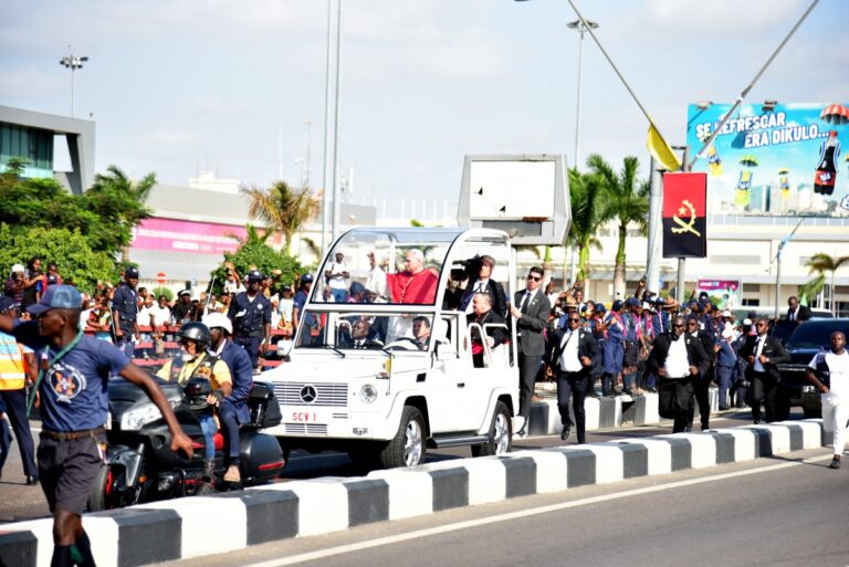 Faithfuls cheer as Pope Leo XIV (C) waves at them from the Popemobile after his arrival at the "4 de Fevereiro" Luanda International Airport in Luanda on the sixth day of an 11-day apostolic journey to Africa, on April 18, 2026. PHOTO: AFP/ JULIO PACHECO NTELA